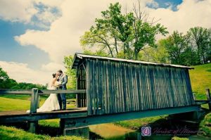 Wedding couple photographed beside a rustic covered bridge at EagleSticks Golf Club