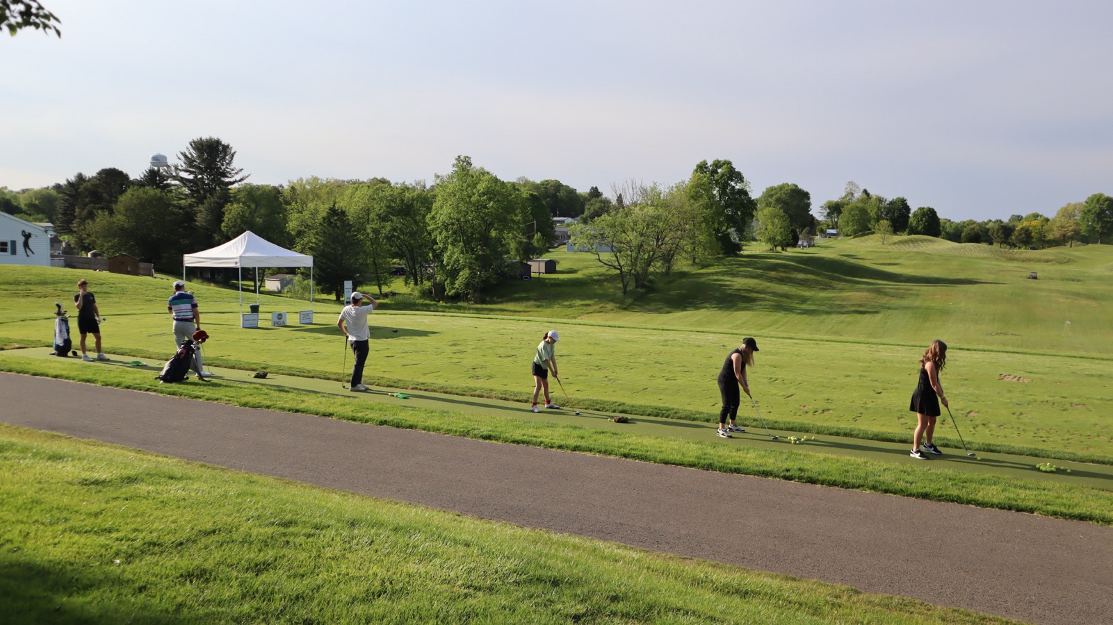 Golfer practicing from a mat at the EagleSticks golf driving range