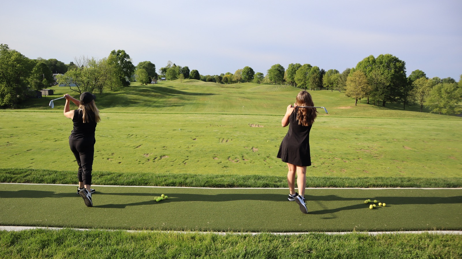 Two women practicing at the EagleSticks golf driving range